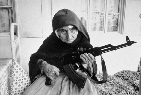 A 106-year-old woman sits in front of her home guarding it with a rifle, in Degh village, near the city of Goris in southern Armenia. (Image Credit: Armineh Johannes / UN Photo)